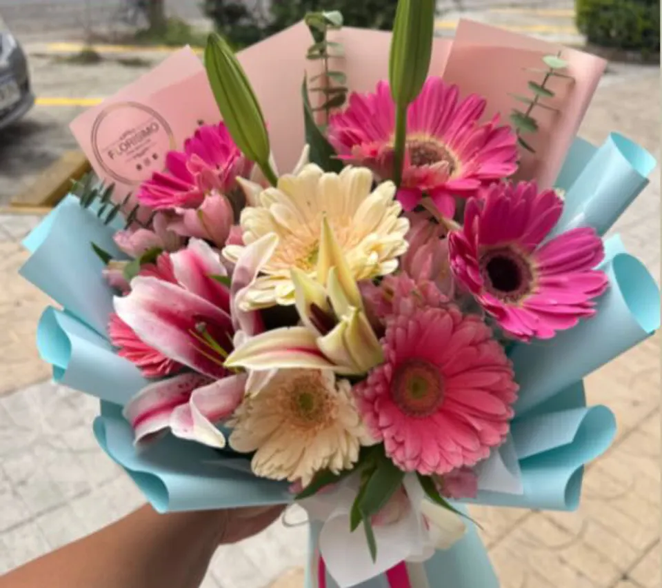Ramo de gerberas y lirios en papel azul